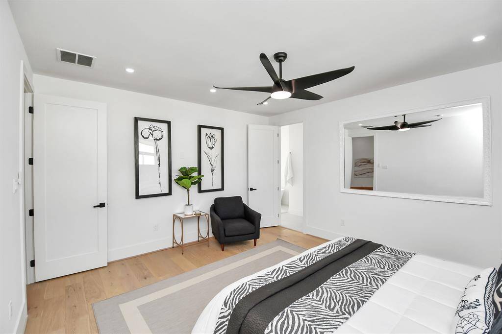Spacious primary bedroom located on the third floor offers versatility, with a cozy seating area and direct access to a luxurious en-suite bath.
