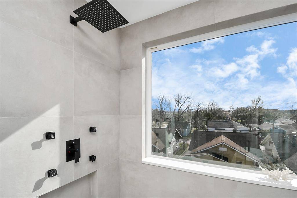Enjoy a refreshing shower experience in a fully tiled shower featuring a large window that fills the space with natural light.