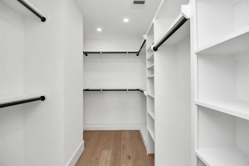 This oversized walk-in closet offers ample storage with custom shelving and hanging space, perfect for organizing your wardrobe.