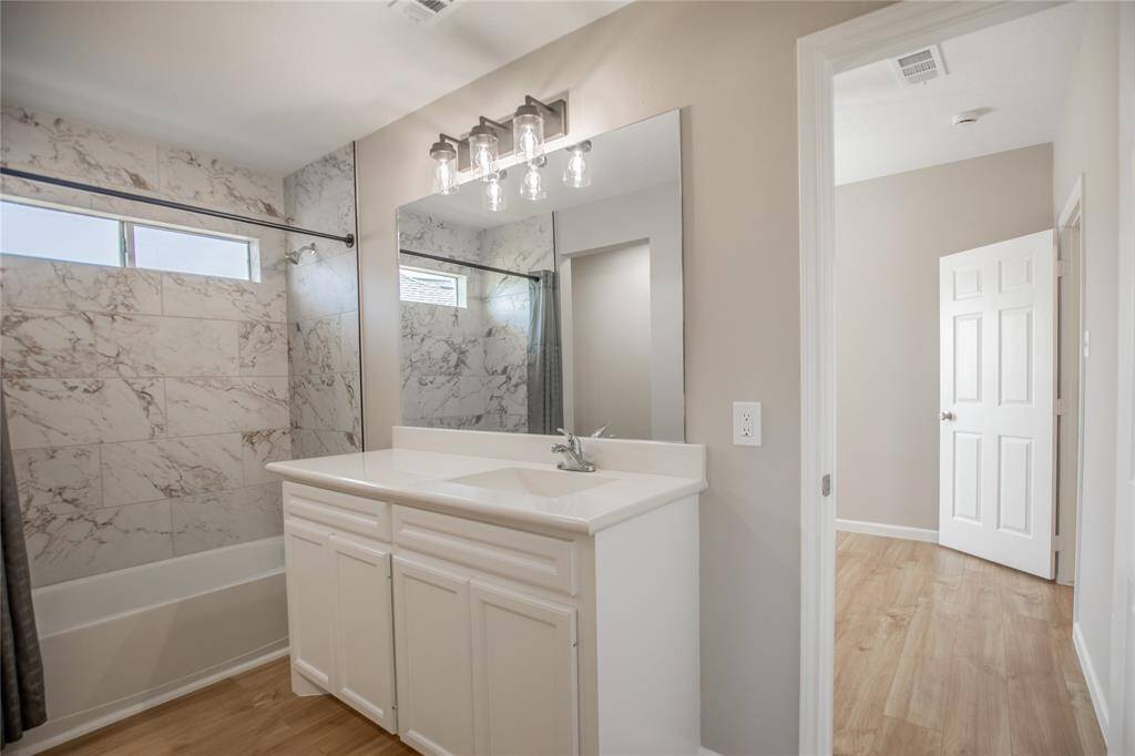 Second floor updated bathroom with new lighting and toilet.