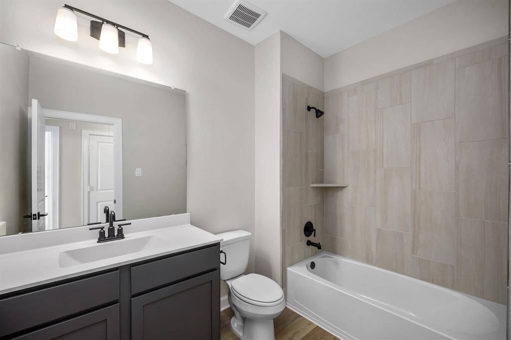 The secondary bathroom features tiled tub/shower combination.