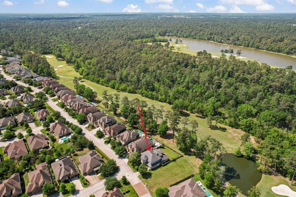 This aerial photo showcases a lush, green neighborhood surrounded by trees and golf courses. It highlights a community of well-organized homes with nearby water features, offering a scenic and tranquil setting ideal for homebuyers seeking a serene environment.