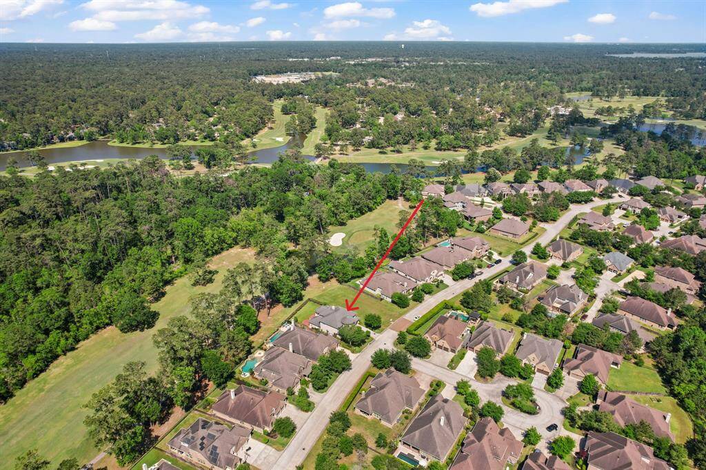 This aerial photo showcases a suburban neighborhood surrounded by lush greenery and a golf course. The homes are arranged neatly with well-maintained streets, offering a serene and picturesque environment.