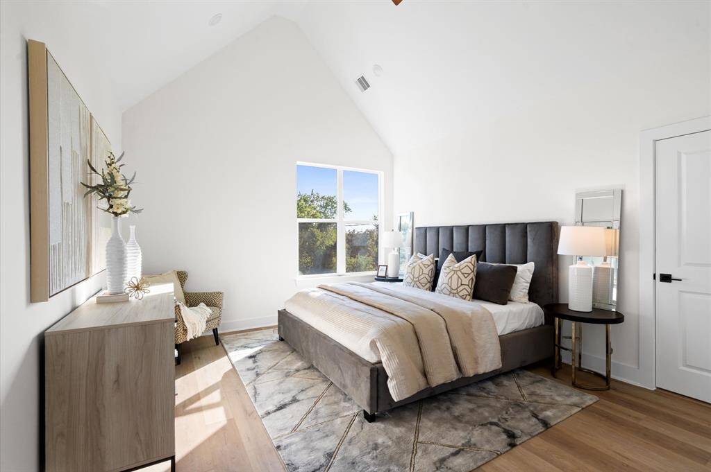 Large primary bedroom has sweeping cathedral ceilings.
