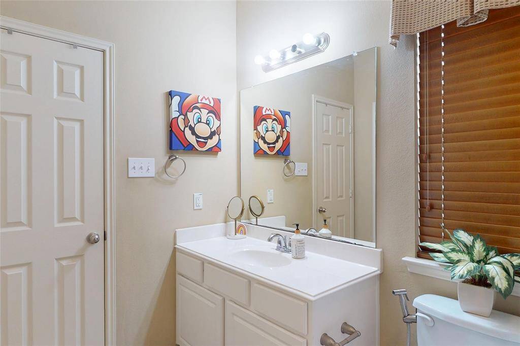 This first floor bathroom features a clean, modern design with a white vanity, large mirror, and tasteful lighting.