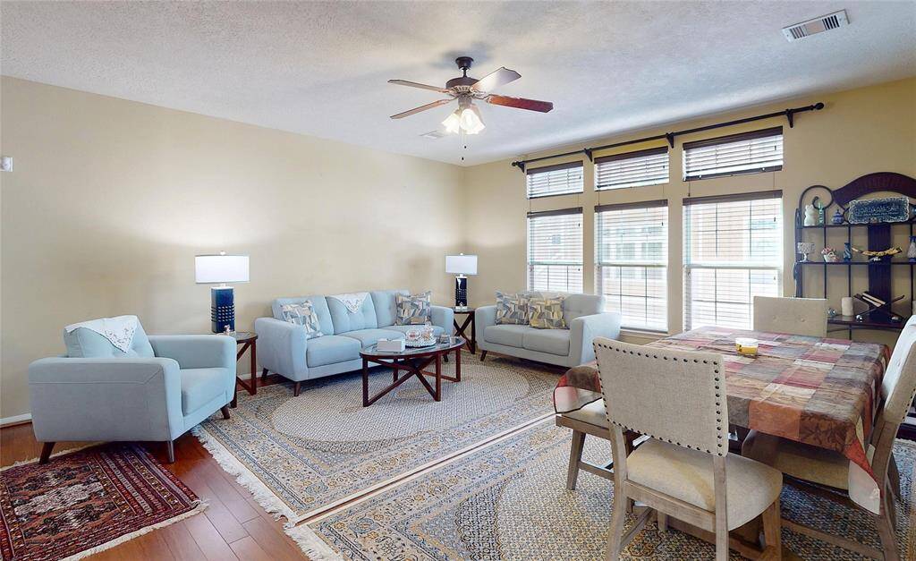 Bright and inviting living room with ample seating and large windows for natural light. Perfect for relaxation and entertaining.
