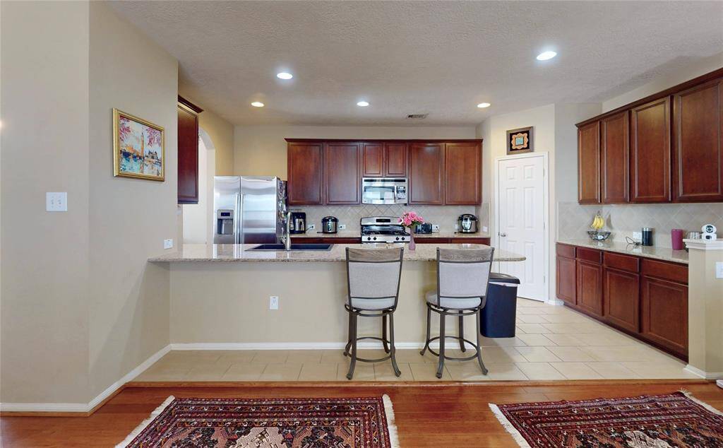 Modern kitchen seamlessly connected to the living room, featuring elegant cabinetry and a spacious layout with a breakfast bar.