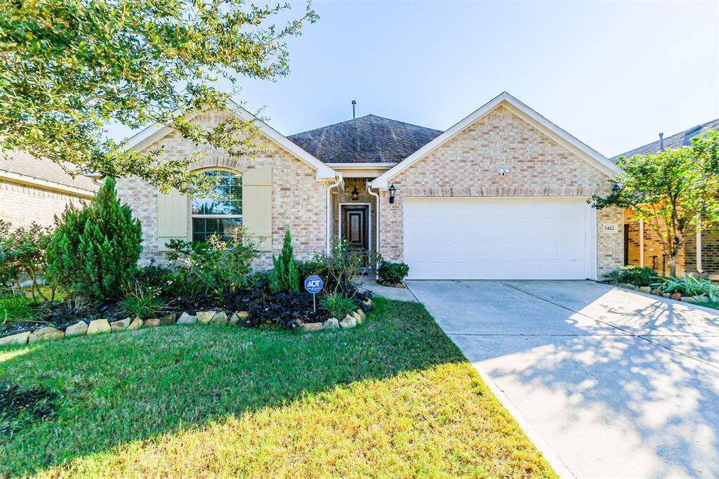 This charming brick home features a well-maintained front yard with mature landscaping, a welcoming front entrance, and a spacious two-car garage. It's situated on a quiet street, offering a peaceful suburban setting.