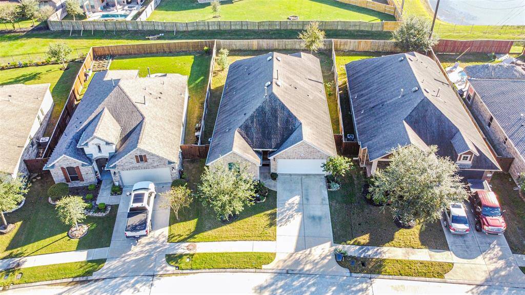 This aerial view showcases this beautiful home with a large back yard and separation between homes behind it. It has a well-maintained front yard and a fenced backyard, offering privacy. Meridiana is peaceful and well-kept, ideal for families.