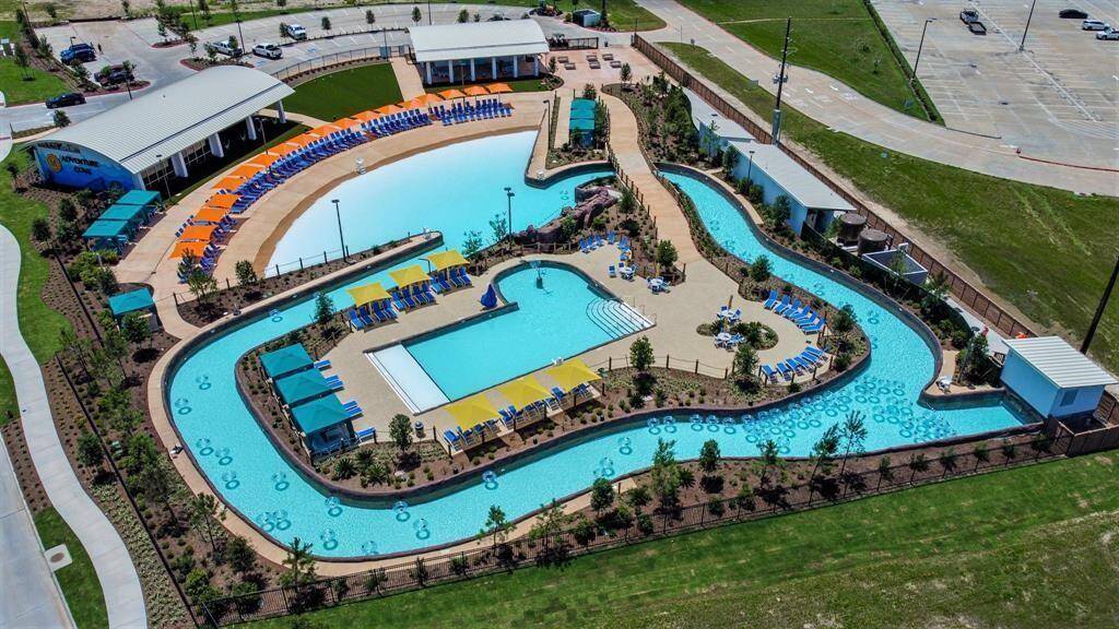 Meridiana's newest amenity, Adventure Cove, features this winding lazy river, ample lounge seating and a fitness center. The facility includes shaded areas and surrounding greenery, offering a resort-like atmosphere perfect for relaxation and recreation.