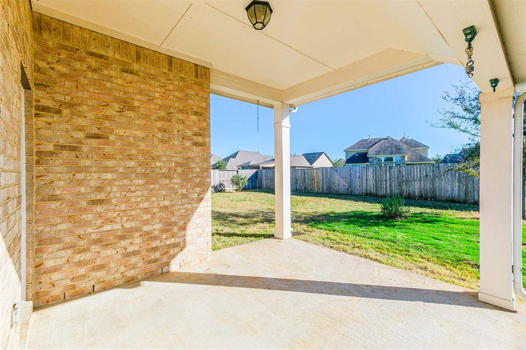 This covered back patio is a perfect blank slate to make it your own. It's ideal for outdoor relaxation and entertainment.