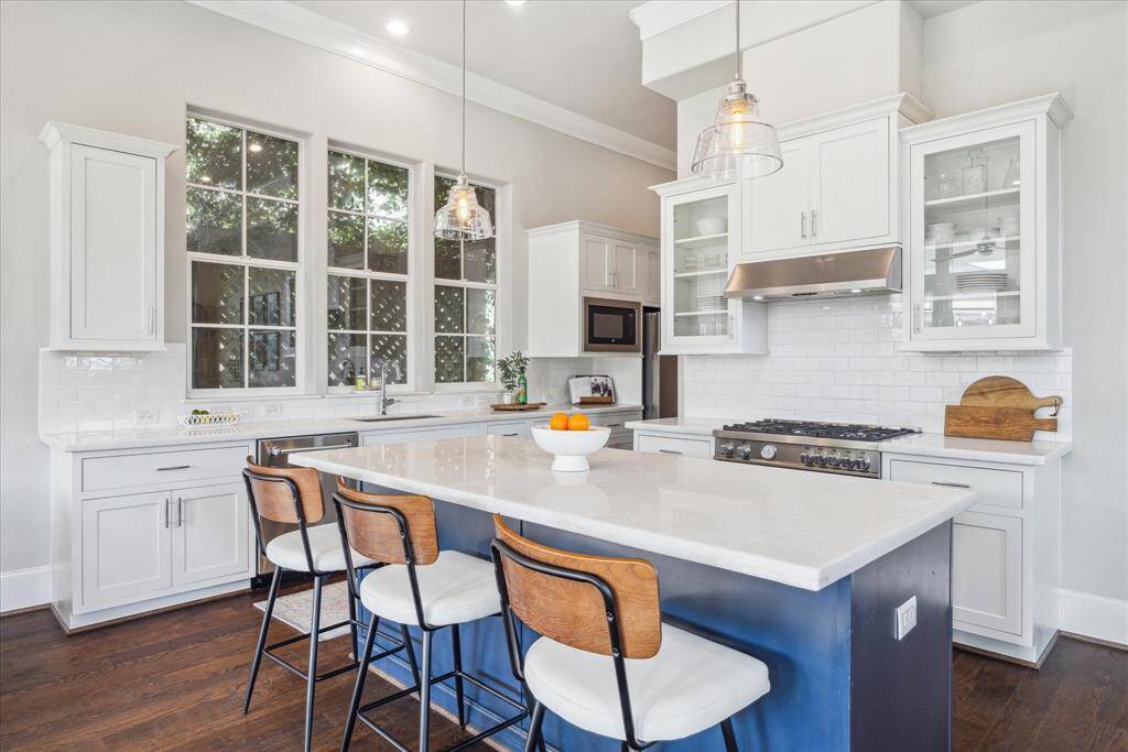 The triple set of windows over the sink area can bring in more light -- or in this case, the owners have chosen a trellis for privacy -- a lovely touch bringing the outdoors in.