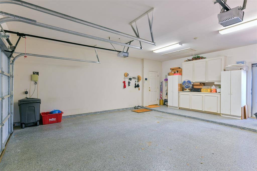 Large garage with cabinets for extra storage. Garage floor has epoxy coating