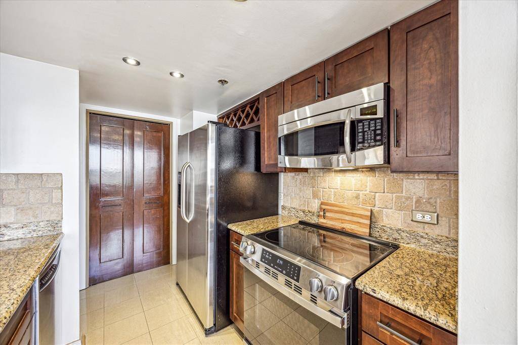 Stainless steel appliances including refrigerator/freezer, 4-burner glass cooktop range with conventional oven below, built in microwave, and dishwasher all stay with the unit.