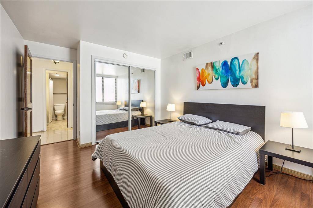 This bedroom features a spacious closet with full-length mirrors.