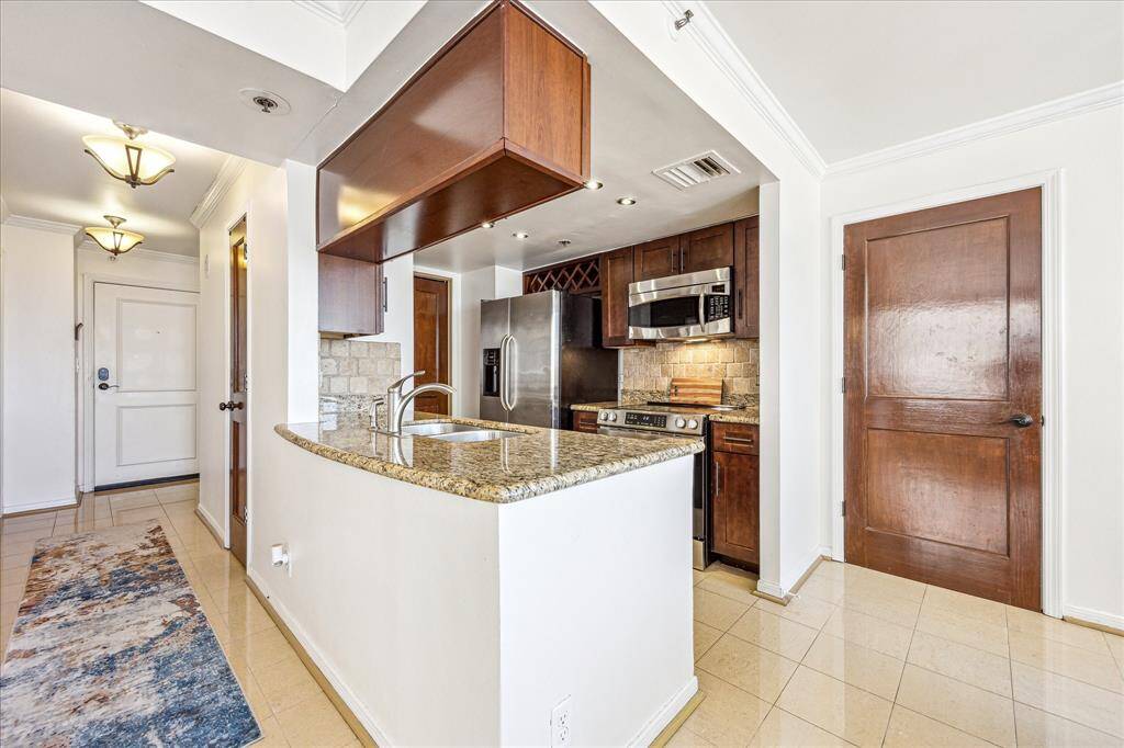 A welcoming view of the front entrance, foyer, and kitchen layout.