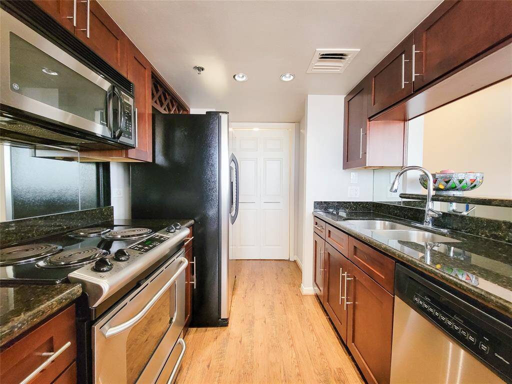 Chef's Kitchen with stainless steel appliances, granite countertops, recessed lighting and laminate flooring. Laundry is located at the end of the Kitchen, as well as pantry space.