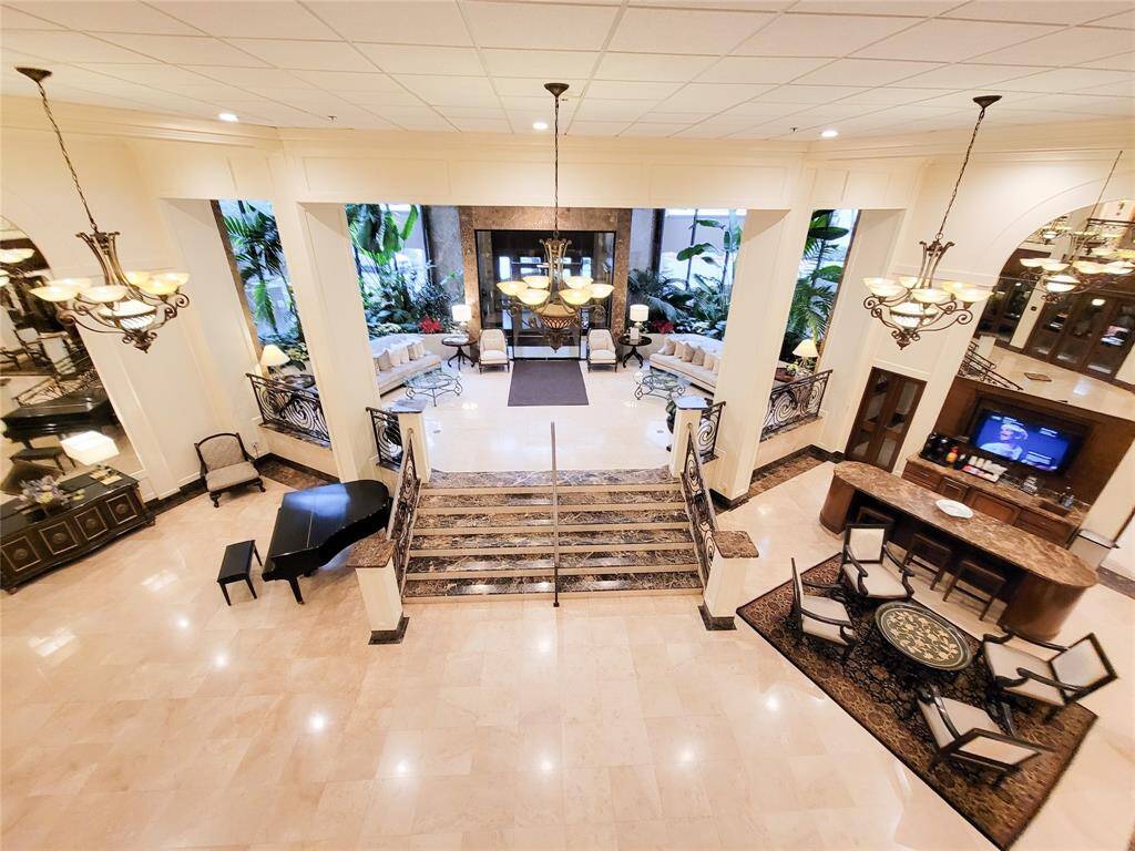 View or the Lobby from the Mezzanine, shows the inviting entrance for residents and guests, the Grand Piano for everyone's use and the Coffee Bar to the right.