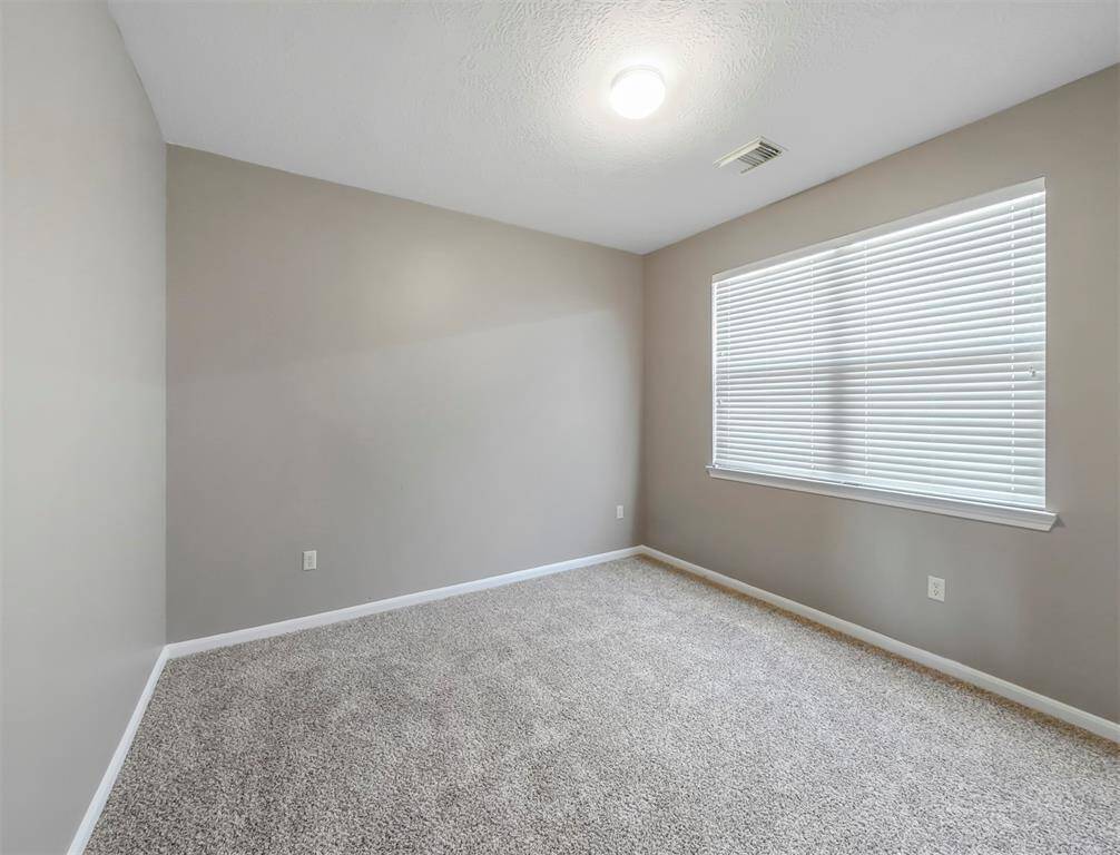 Gray carpet, neutral walls, and a bright window.