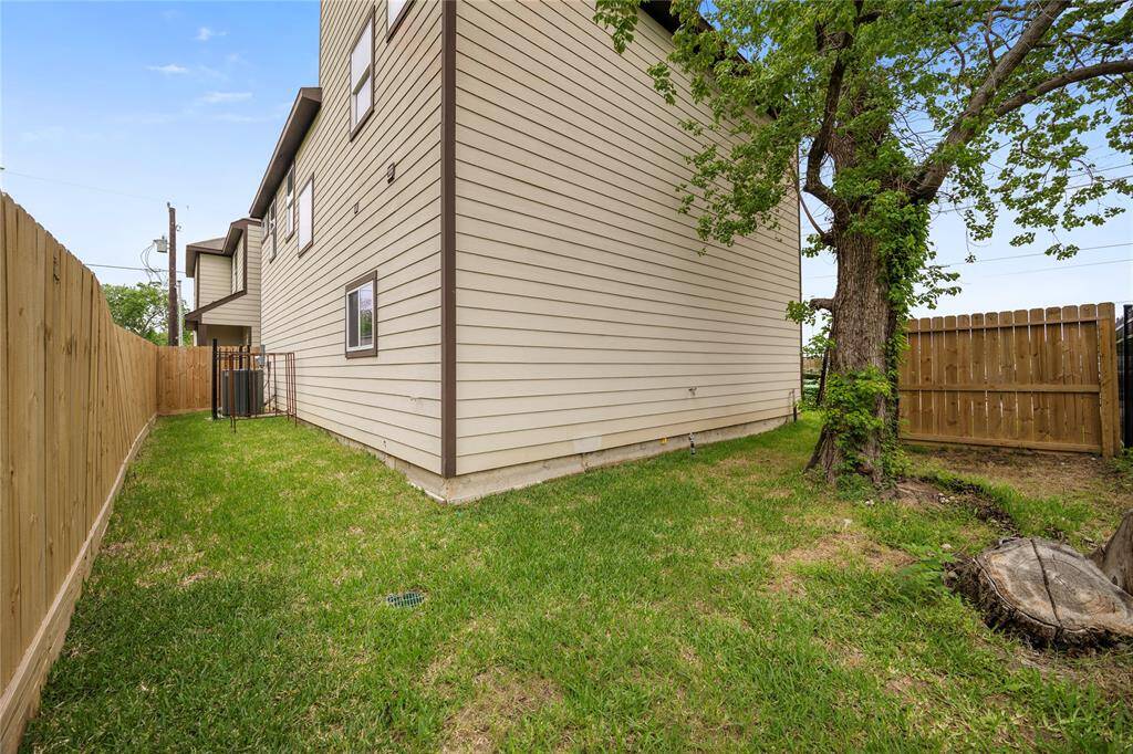 Side yard with shade tree for relaxing and grilling your favorite meal.