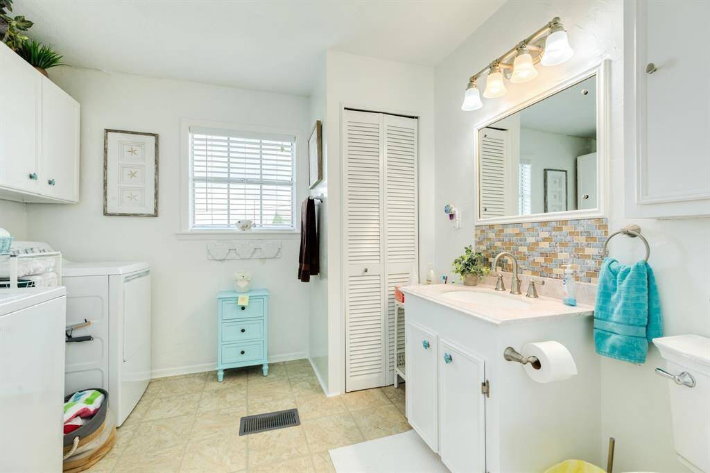 Full bath with colorful backsplash and a bonus laundry zone.