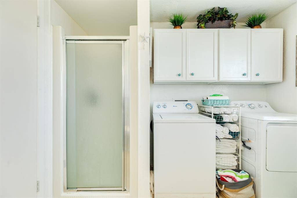 Laundry area with built-in cabinets and a separate shower—ideal for sandy days.