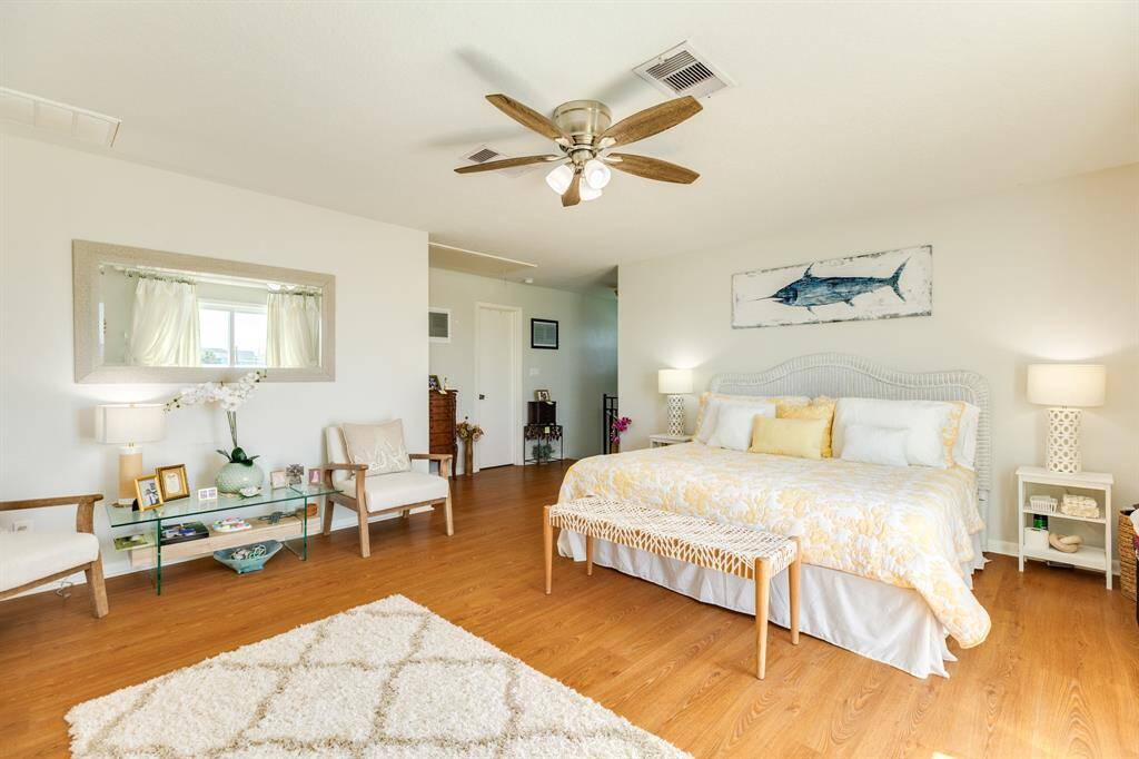 A large primary bedroom filled with light and coastal charm.