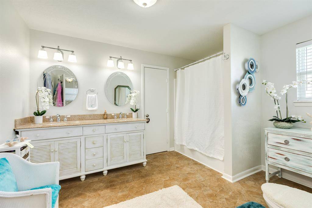Oversized bathroom with dual sinks and beachy finishes.