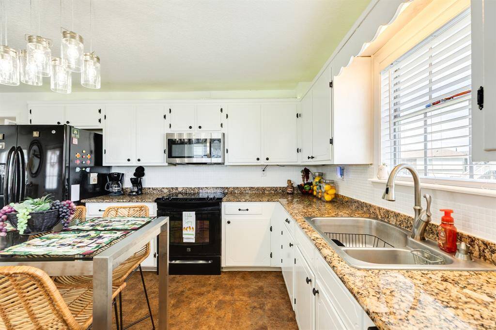 Sleek granite countertops, double basin sink, and stainless appliances shine.
