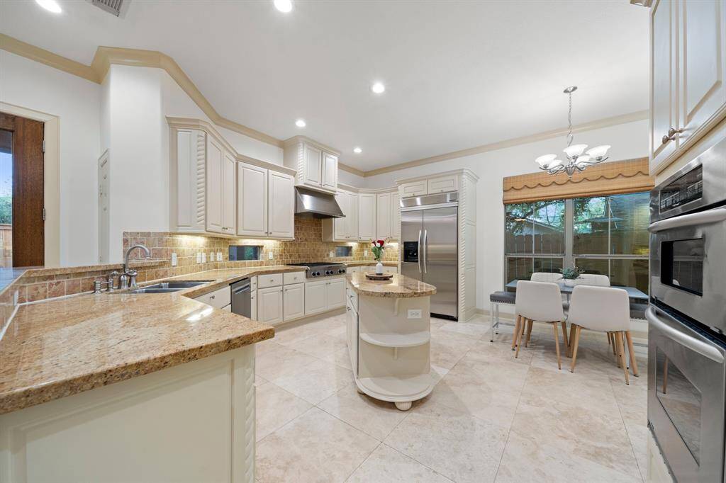 Elegant rich resurfaced wood cabinetry and granite counters with large kitchen island