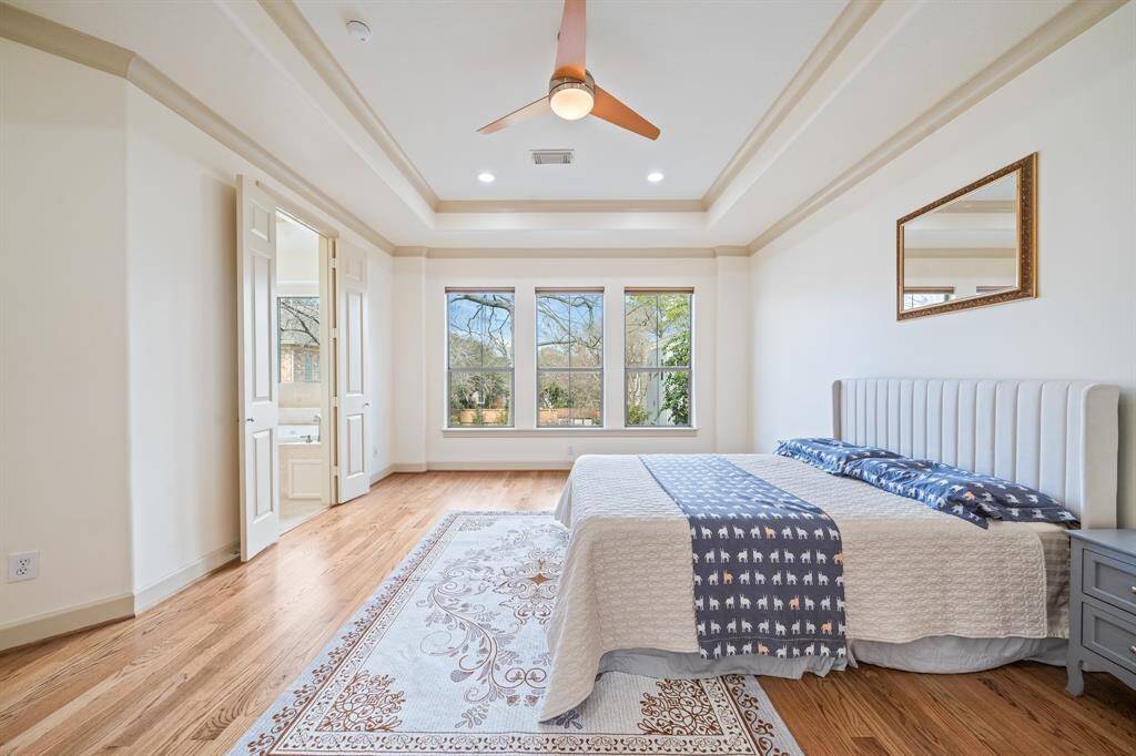 Wonderful atmosphere in this lovely master suite with the wall of windows and hardwood floors