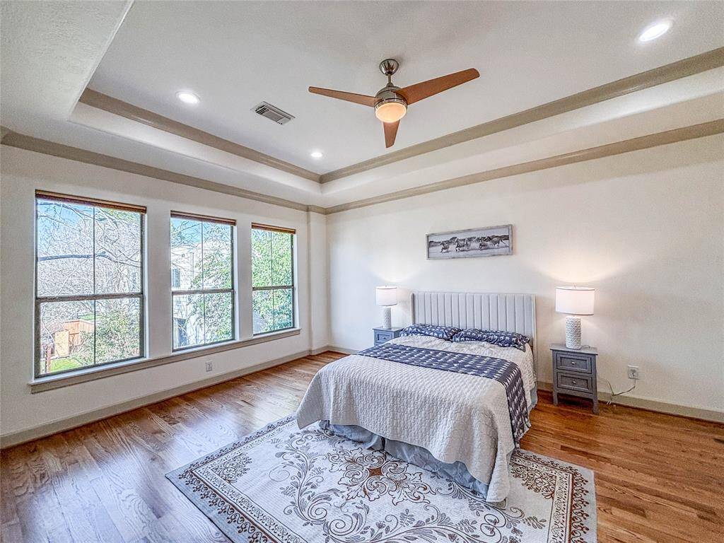 Wonderful atmosphere in this lovely master suite with the wall of windows and hardwood floors
