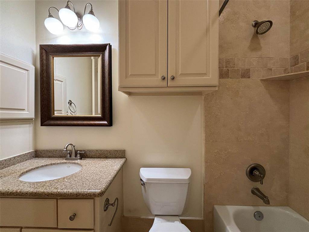 Granite vanity, framed mirror and tub/shower are in the hall bath