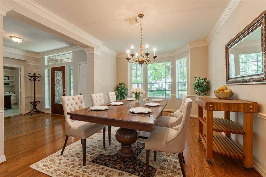 Formal dining room with crown molding and bay windows.Virtually staged