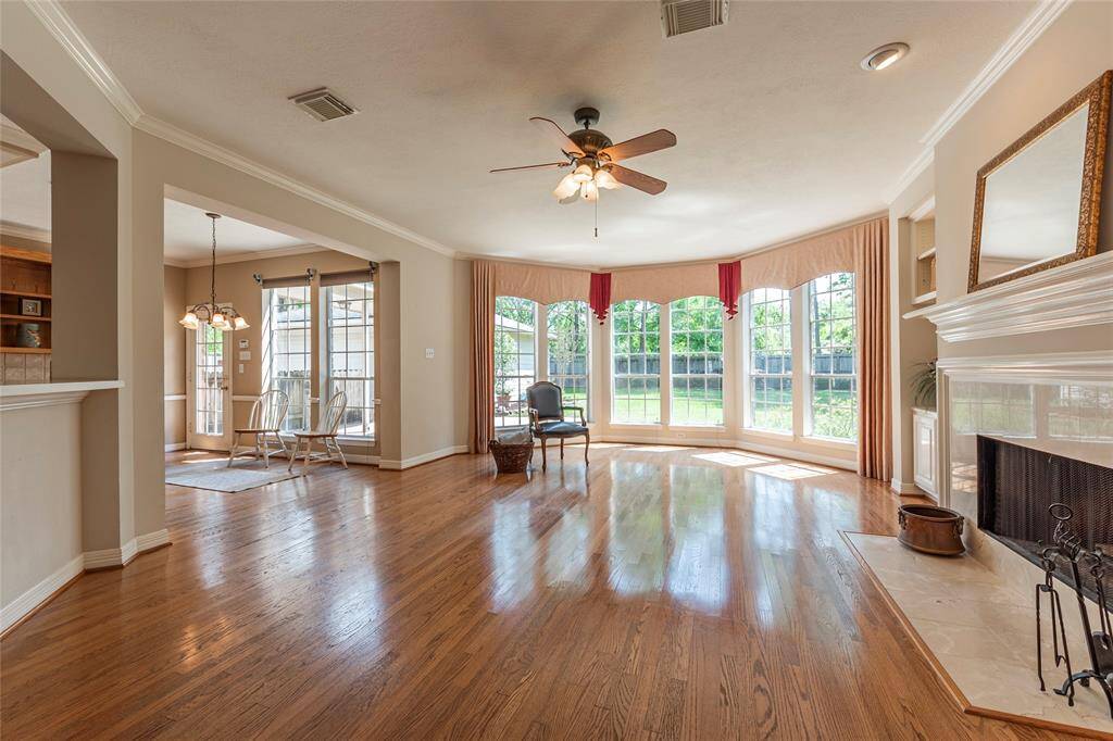 Crown molding and wood floors in the family room with wall-of-windows.
