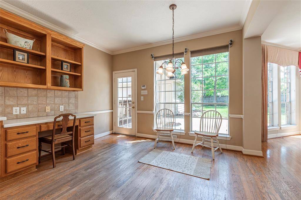 Wood floor breakfast area with great natural lighting and backyard views. Built in workspace to the left.
