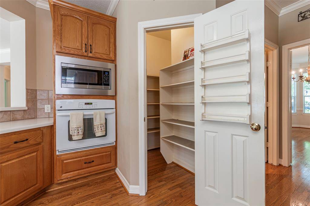 Large walk in pantry with ample storage and built-in spice rack.