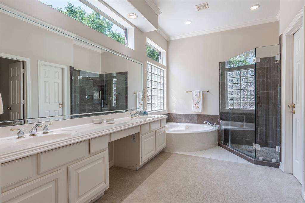 Beautiful primary bath with his/her sinks, large vanity mirror, windows above for natural light.
