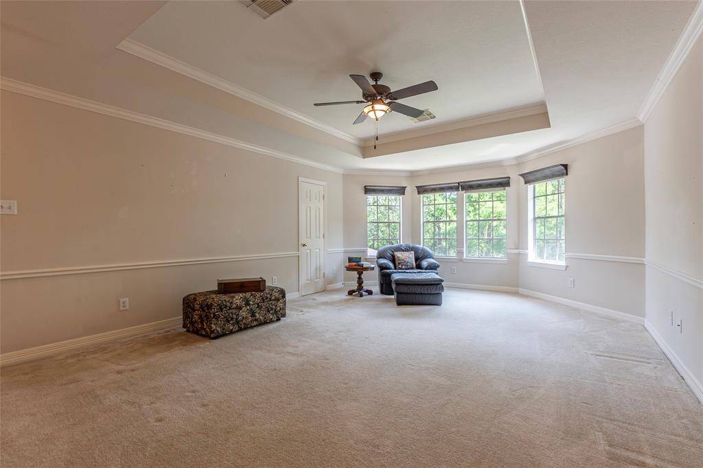 Large game room with high ceilings, storage closet and crown molding.