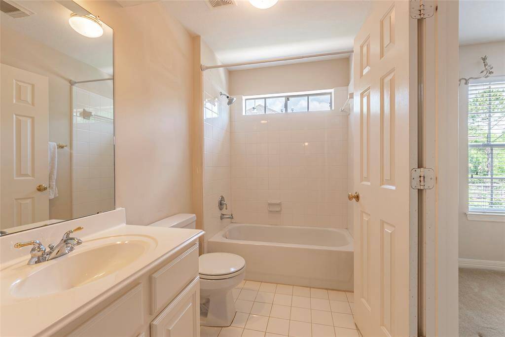 Full sized bath with tile flooring and shower/tub combination.