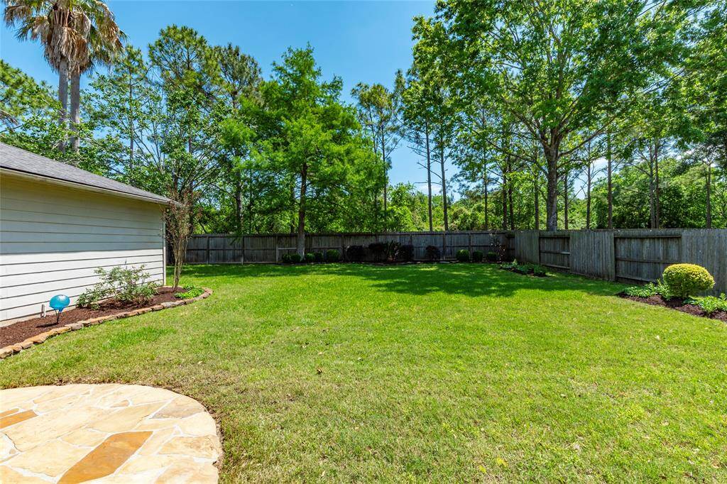 Huge backyard area with mature trees along the fenceline.