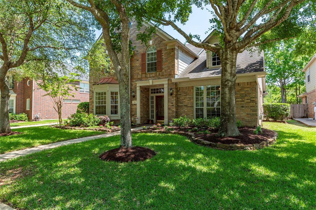 Mature trees provide great shade to the landscaped front yard.