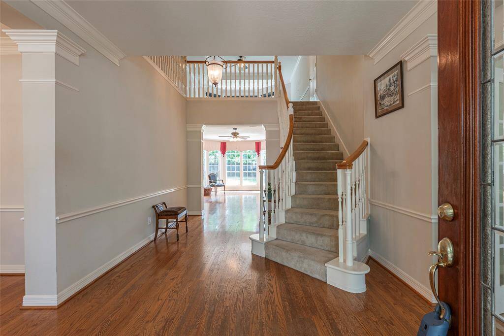 Entryway with wood floorings and curved staircase.