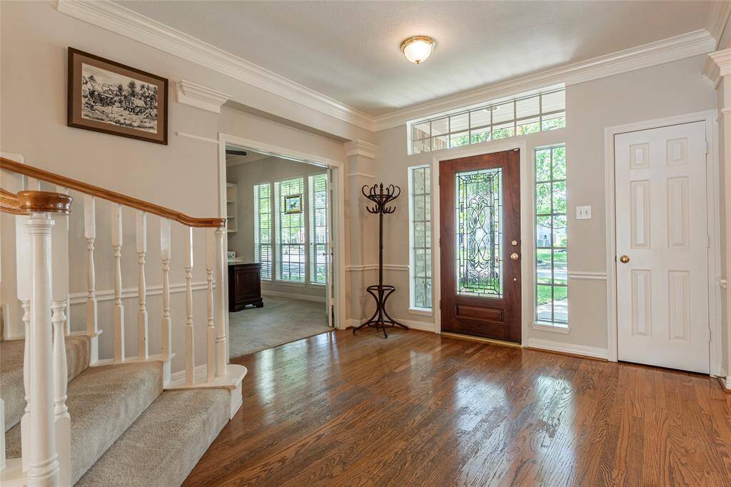 Wood floor entryway with glass panel front door.