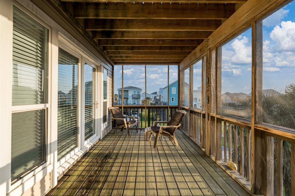 The second-level screened-in porch offers a perfect blend of comfort and fresh air, providing an ideal space to relax while being shielded from the elements.