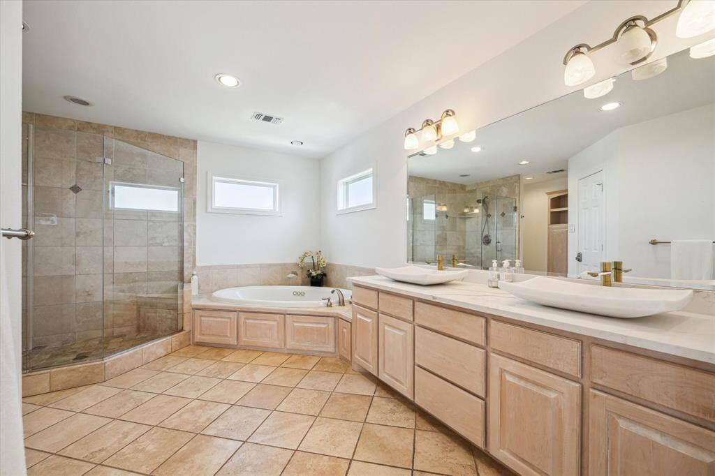 The primary ensuite features a double sink vanity, jetted tub and large glass-enclosed shower.  A walk-in closet provides abundant storage.