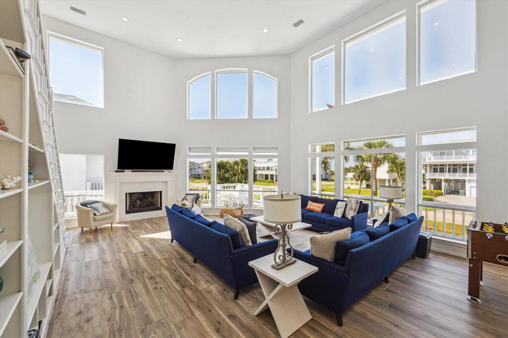 Additional view of the living room, highlighted by the fireplace and wall of windows.