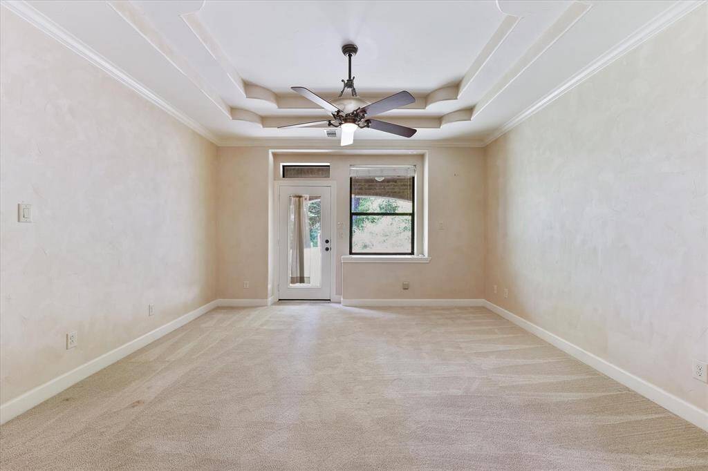 The tiered ceiling in the primary suite adds an elegant touch.  The door leads to a private patio.
