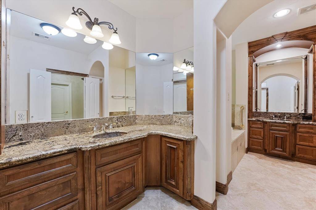 The primary ensuite is very large and features granite countertops, a jetted soaking tub, and separate walk-in shower.