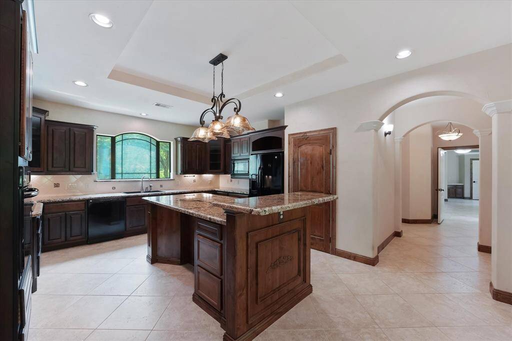 Elegant, ornate cabinetry and beautiful granite counters complete the look of this centerpiece kitchen!